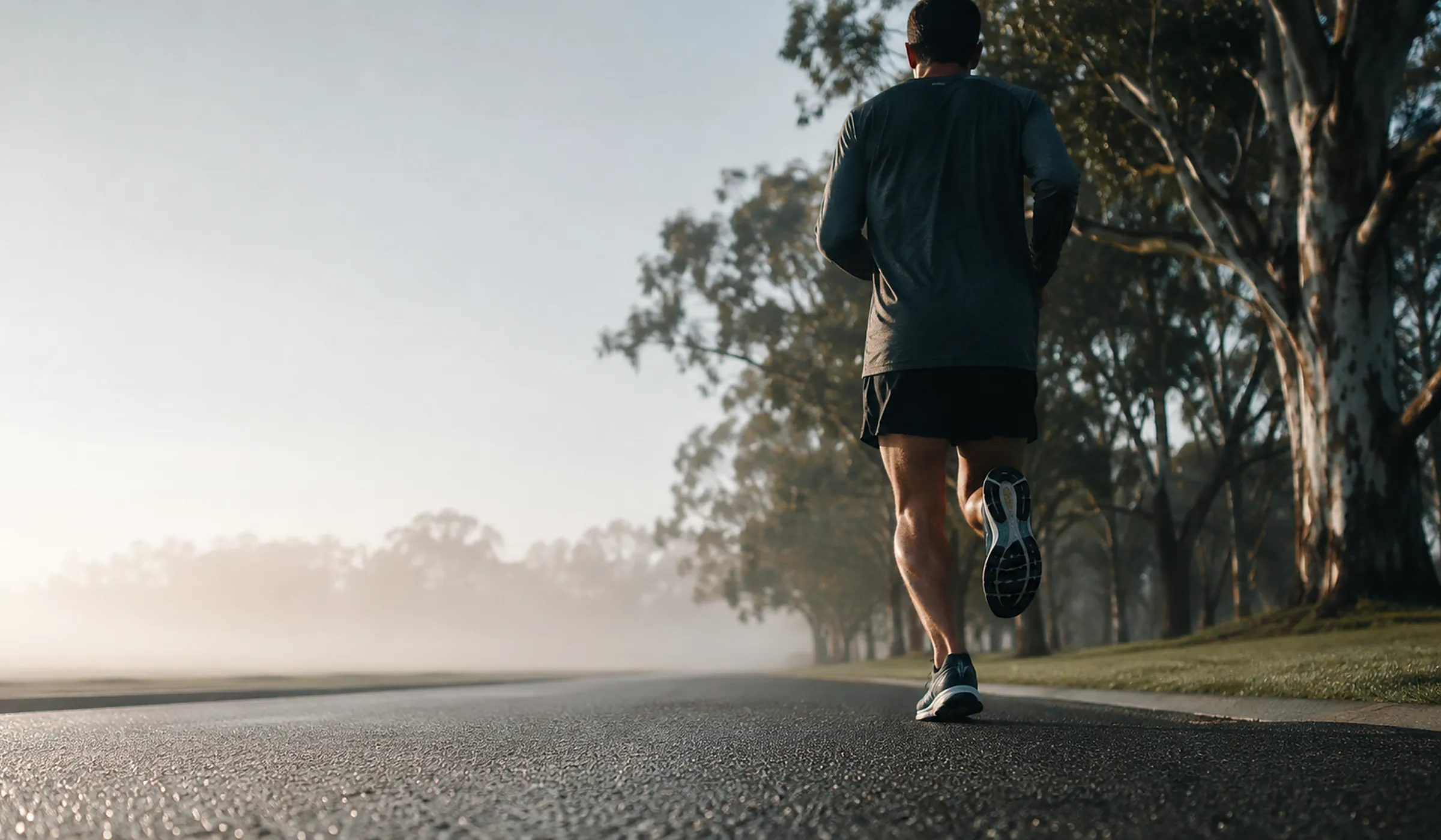 A runner on an empty road at sunrise.